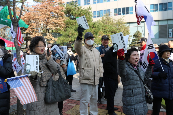 ▲ 집회에 참가한 애국우파시민들이 '손석희의 저주'를 들고 구호를 외치고 있다. 